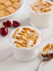 2-ingredient Japanese cheesecake recipe in a small glass next to fresh cherries and a spoon with a white marble background.