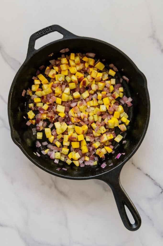 Sautéed diced yellow squash, red onion and garlic in a cast iron skillet.