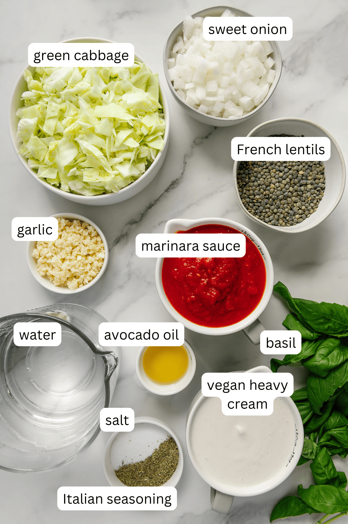 Vegan cabbage soup ingredients with a white marble background.