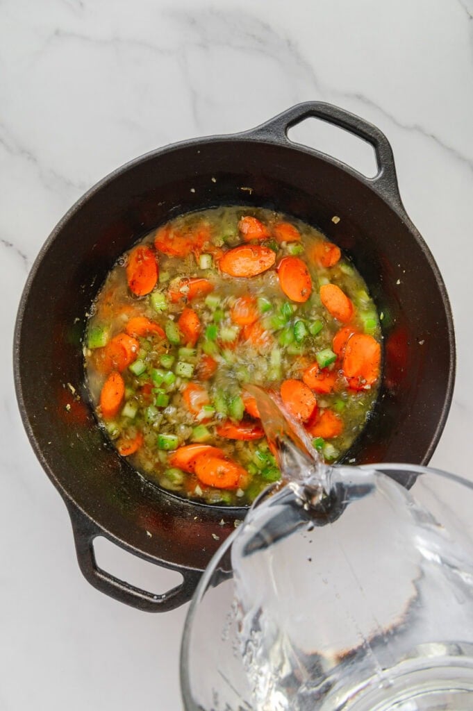 A pot of vegan Italian wedding soup featuring carrots and celery.